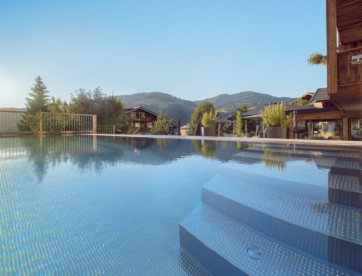 Infinity Pool im Sommer mit Liegen und Sonnenschirme